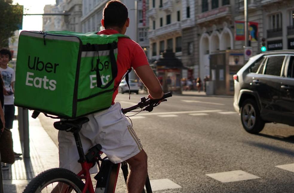 Delivery cyclist from Uber Eats riding through the bustling streets
