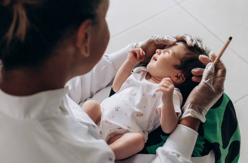 A medical professional examines a newborn baby indoors, highlighting healthcare and care