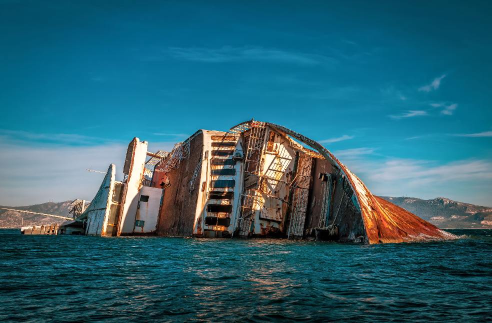 A sunken ship partially submerged in the ocean near the Greek coast.