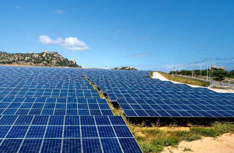 India’s green energy growth faces transmission challenges A vast array of solar panels under a clear blue sky, symbolizing renewable energy and sustainability.