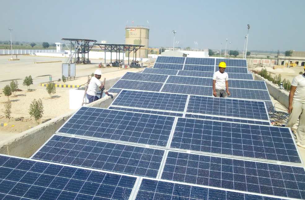 Workers installing solar panels on a rooftop for renewable energy generation.