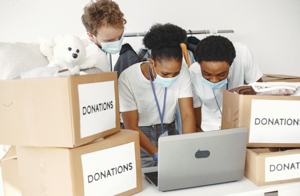 Group of volunteers wearing masks sorting donations