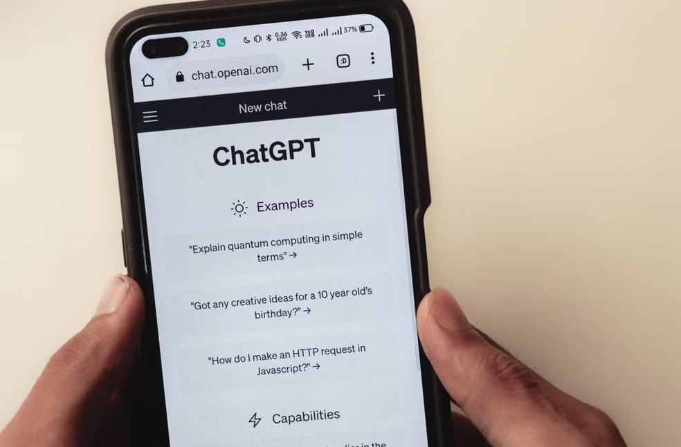 Close-up of hands holding a smartphone displaying the ChatGPT application interface on the screen