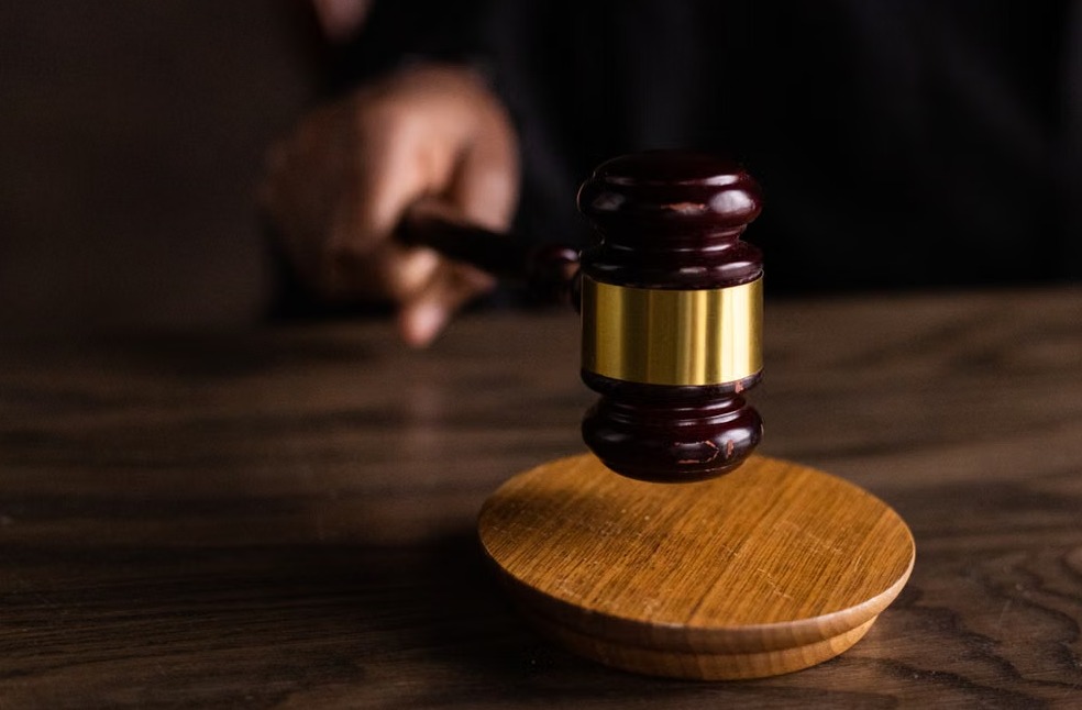 A gavel striking a sound block, symbolizing justice and legal authority in a courtroom setting