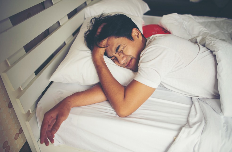 A man in bed feeling tired