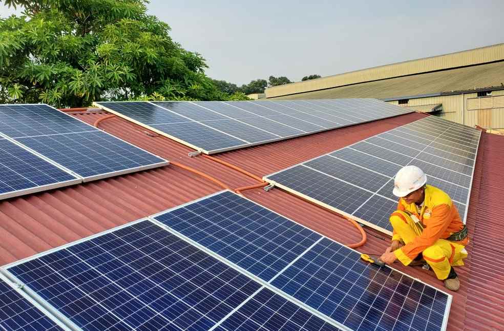 A solar technician performs maintenance on rooftop solar panels enhancing energy efficiency