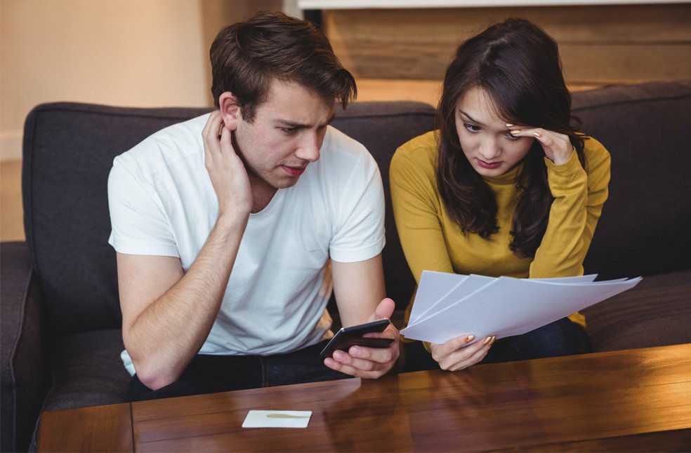 Students sitting on a sofa discussing financial documents