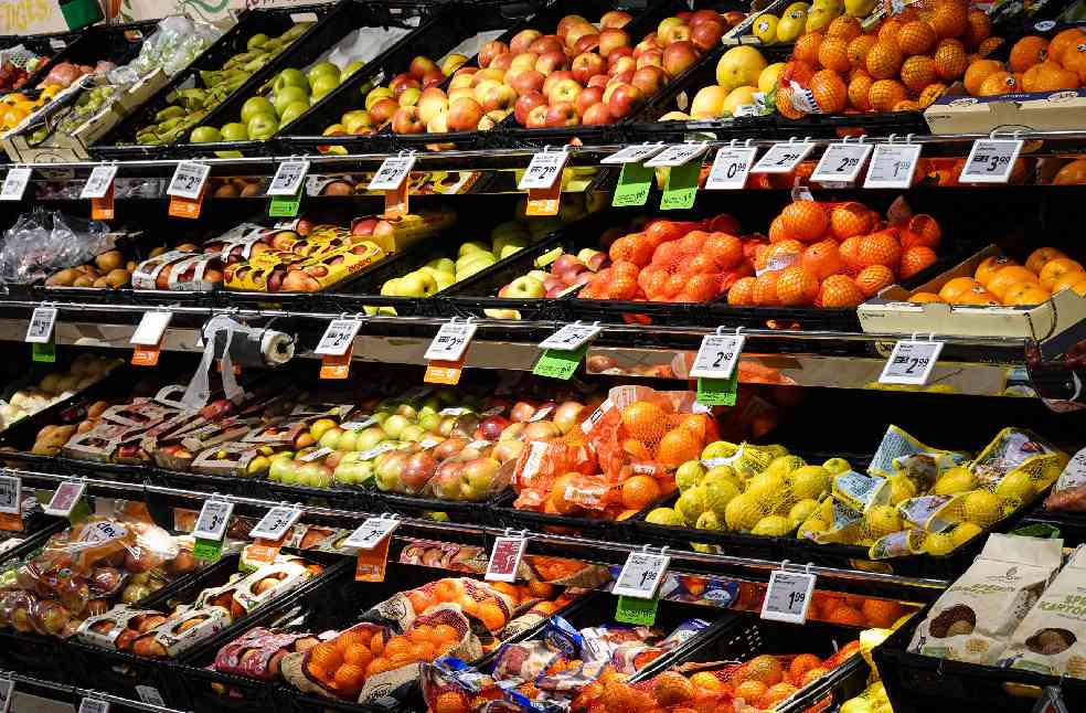 Colorful assortment of fresh fruits neatly arranged on supermarket shelves, ideal for healthy eating themes.