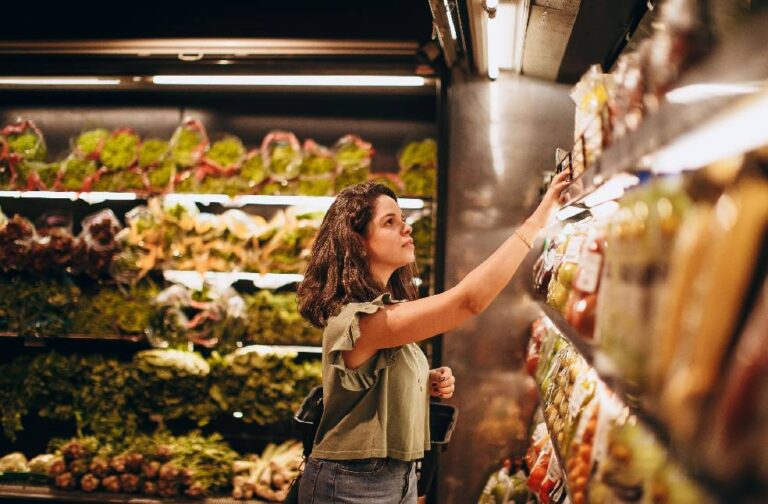 Healthier food sales could cut US diet-related deaths, study shows A woman selects fresh vegetables in a well-lit supermarket produce aisle.