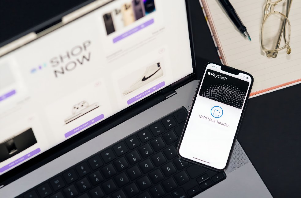 Laptop and smartphone showcasing online shopping and mobile payment setup on desk