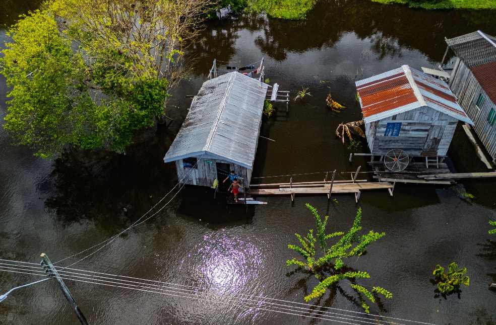 Aerial view of palafitos amidst flooded waters in Amazonas, Brazil, showcasing rural life.