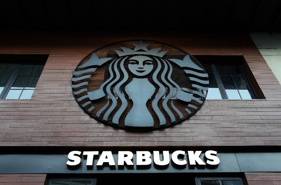 Low angle shot of Starbucks building exterior with logo and windows.